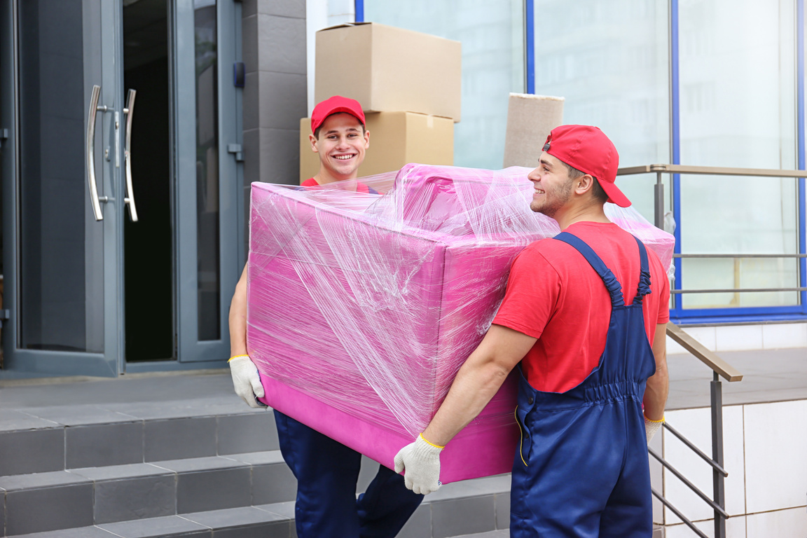 Two Male Workers Carrying Pink Armchair